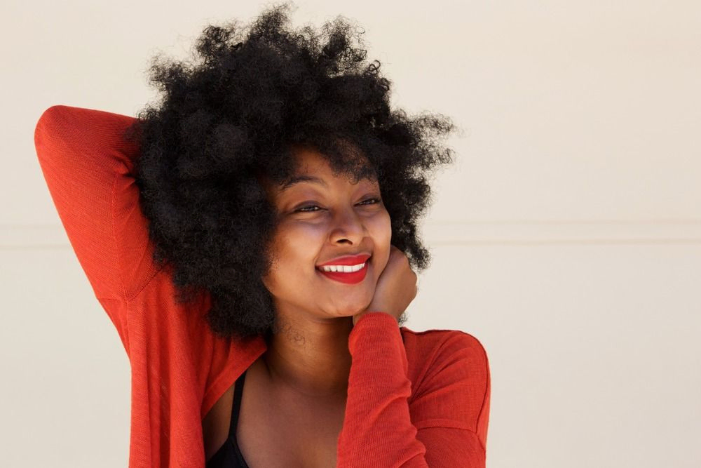 mujer de pelo afro despeinada y sonriente