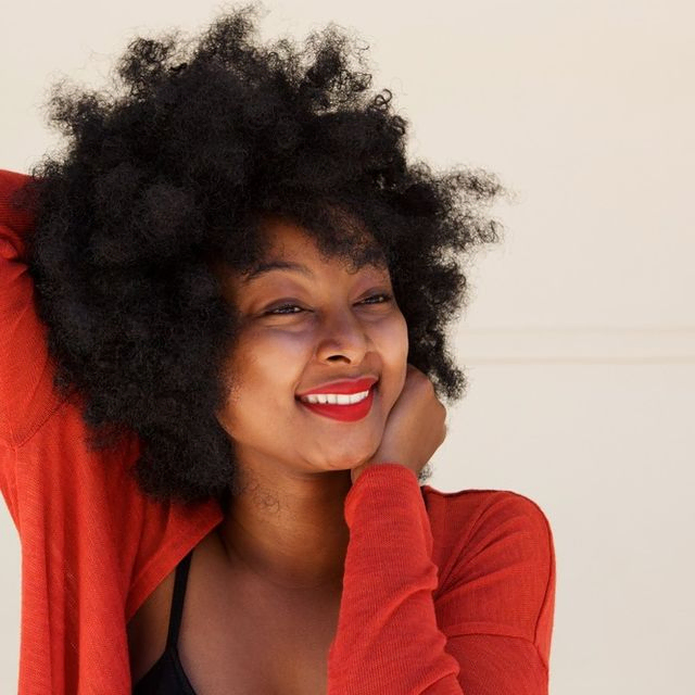 mujer de pelo afro despeinada y sonriente